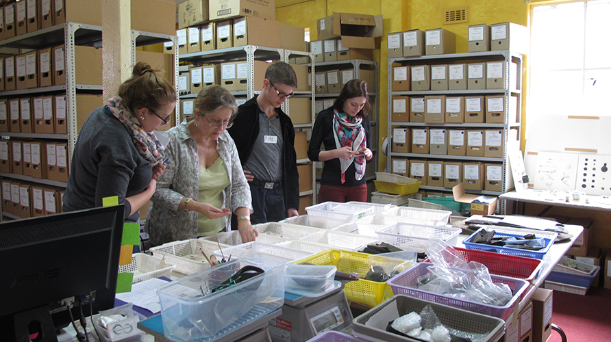 Robyn Stocks (centre) shows workshop participants various miscellaneous artefacts